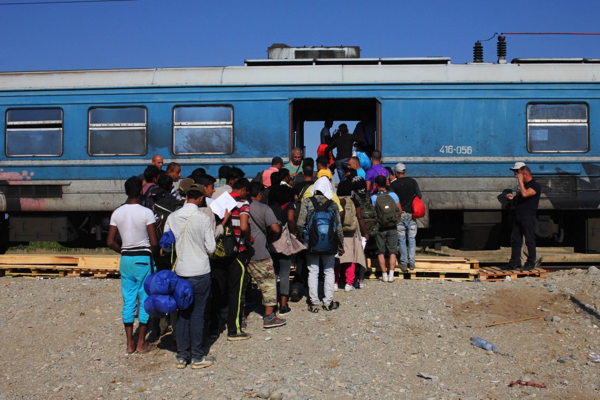 Un grup de refugiats pujant al tren a Gevgelija