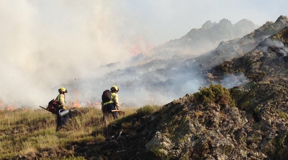 Bombers treballant en l'extinció de les flames a la muntanya de Cerbi