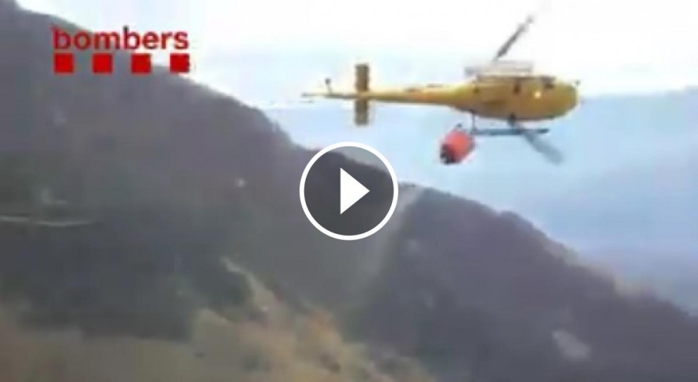 Un helicòpter descarregant aigua en un flanc