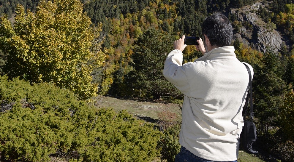 Una persona fa una foto amb el seu mòbil a un paisatge