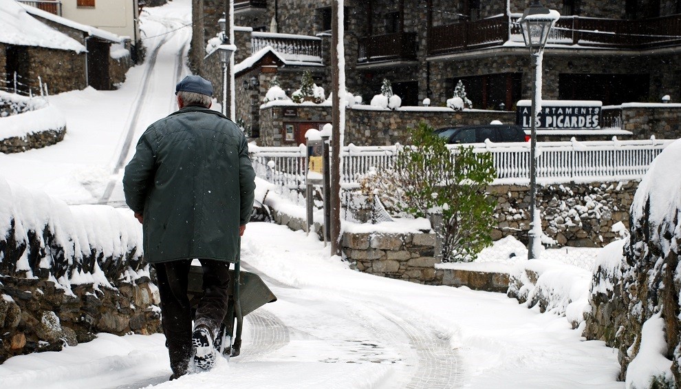 Un home camina per un carrer ple de neu a Espot, en imatge d'arxiu