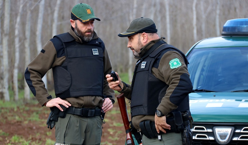 Imatge de dos agents amb armes i armilles