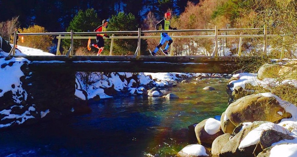 Dos participants de la Foc de Neu creuant un pont al Parc Natural