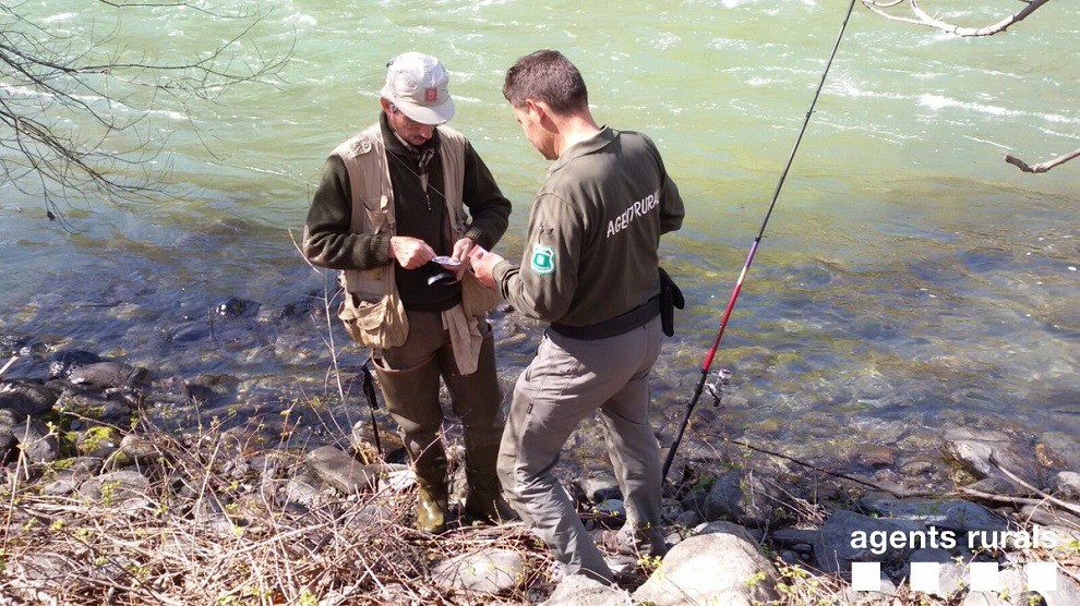 Un agent inspeccionant un pescador al riu Noguera Pallaresa
