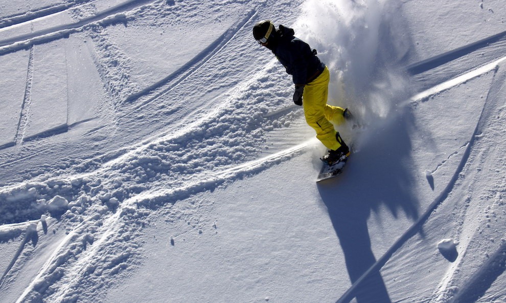 Un jove practicant snowboard sobre neu sense trepitjar
