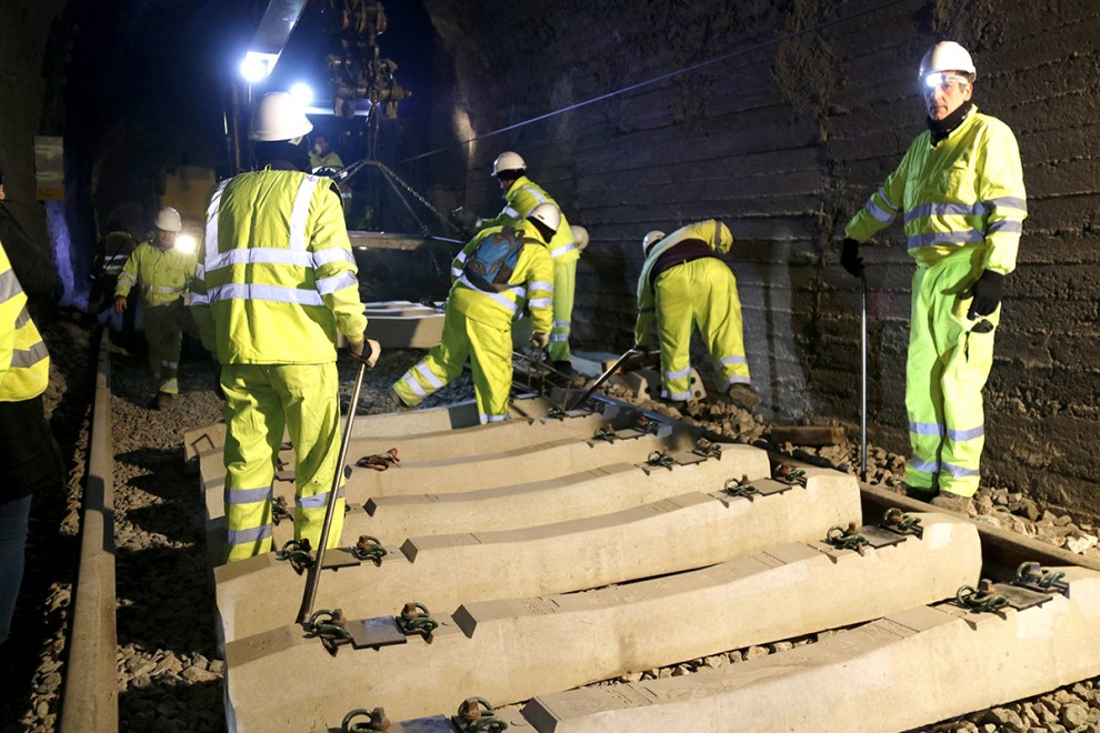 Operaris treballants de nit per la renovació de la via d'un túnel.