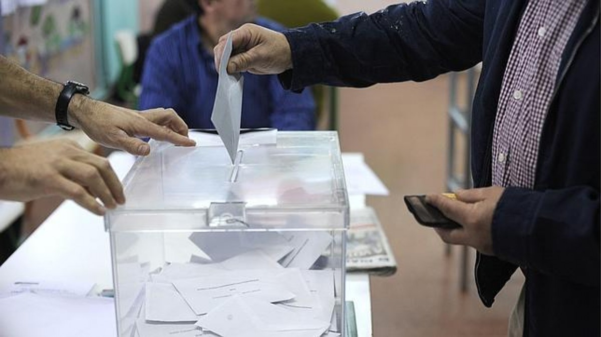 Votants introduint el seu vot en una urna