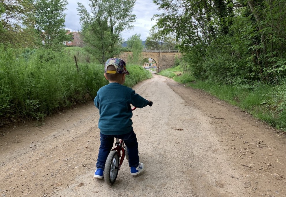 Un nen passejant amb la seva bici per una zona verda de Tremp aquest diumenge