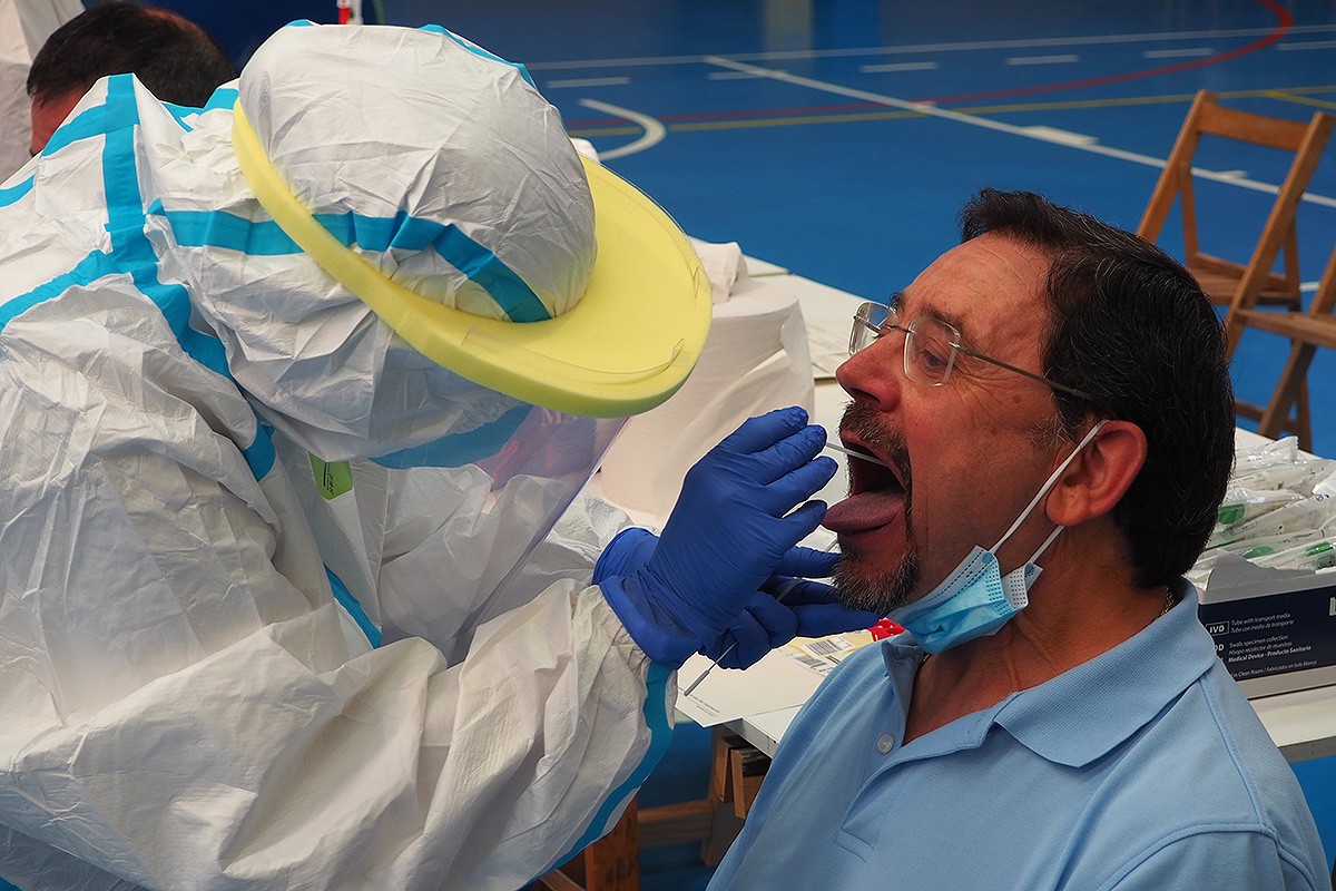 Un home fent-se la PCR amb un tècnic sanitari en una població catalana