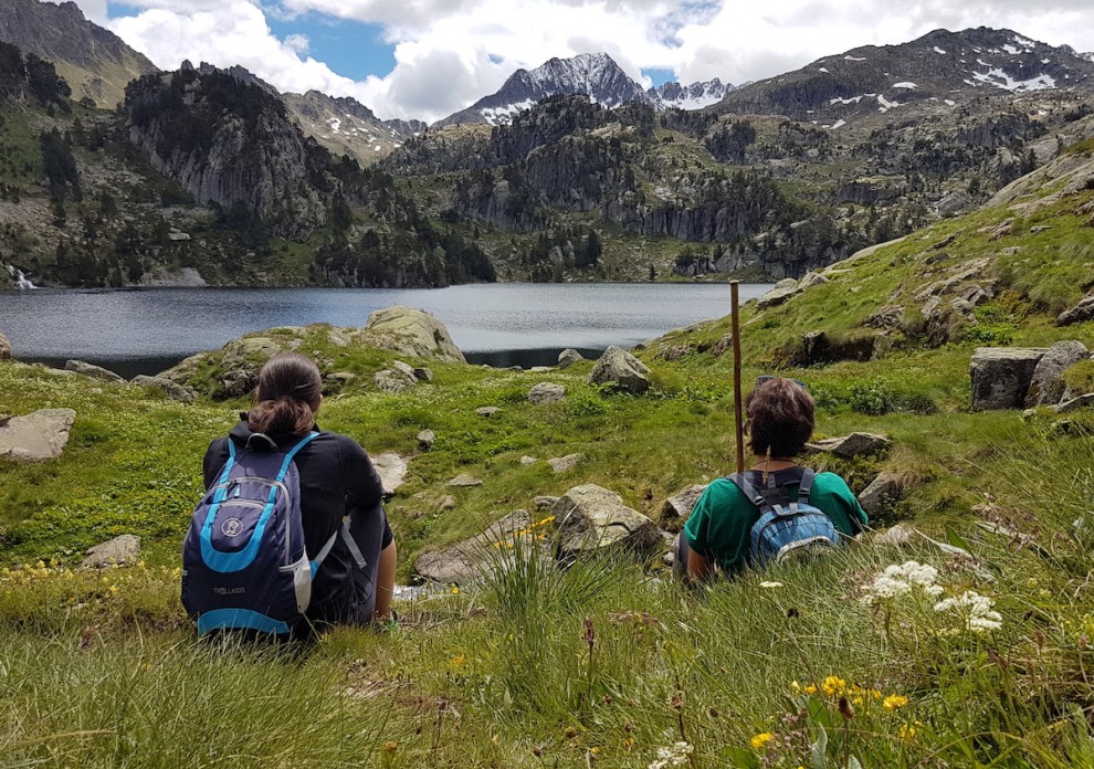 Dos excursionistes descansen al llac de Colomèrs