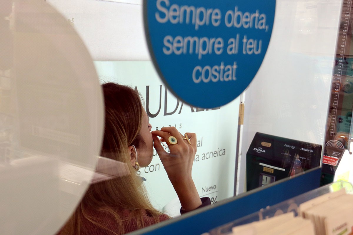 Una noia fent-se un test d'antigen en una farmàcia catalana