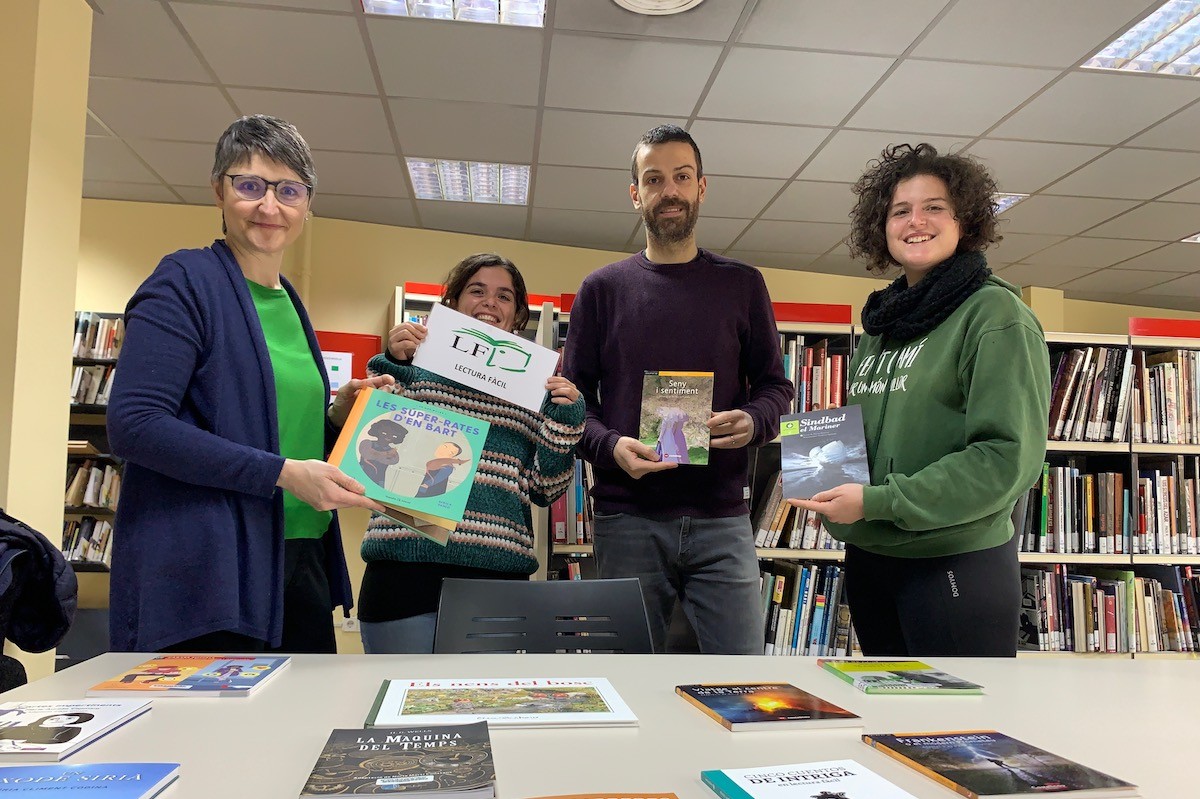 Membres de la biblioteca, de Pallars Digital i Alba Jussà mostren alguns dels llibres cedits