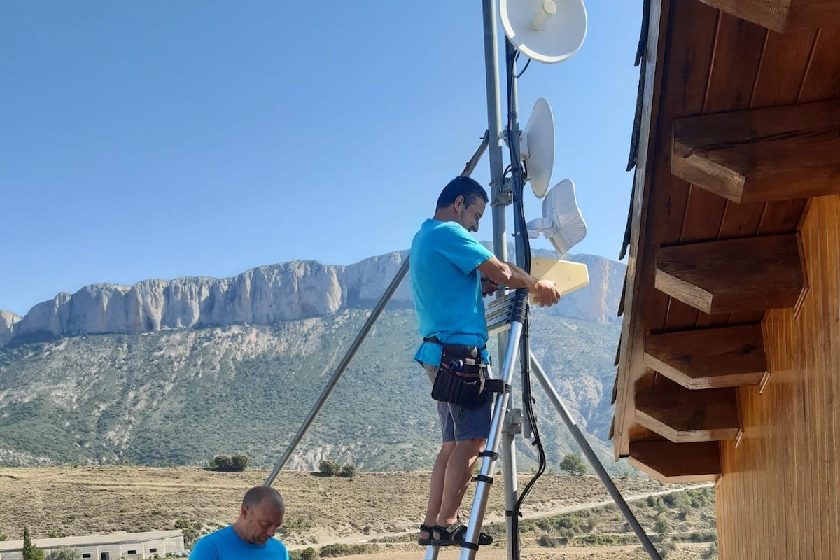 Dos operaris instal·lant una antena a la Terreta