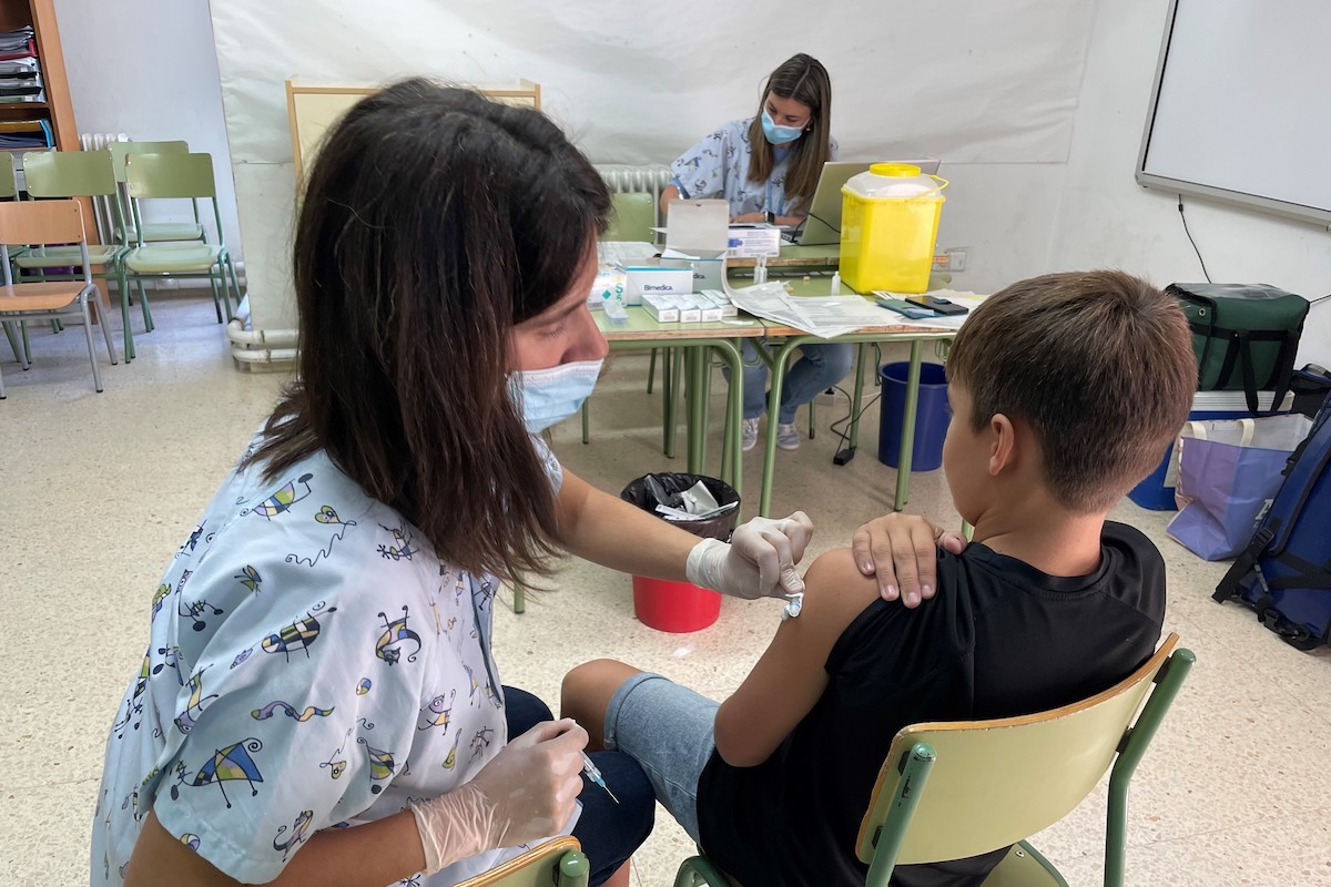 Una infermera administrant una vacuna a un alumne d'El Pont de Suert