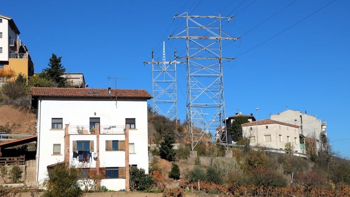 Imatge d’una torre d'alta tensió passant a escassos metres d'una casa del barri de la Pedrera de Tremp