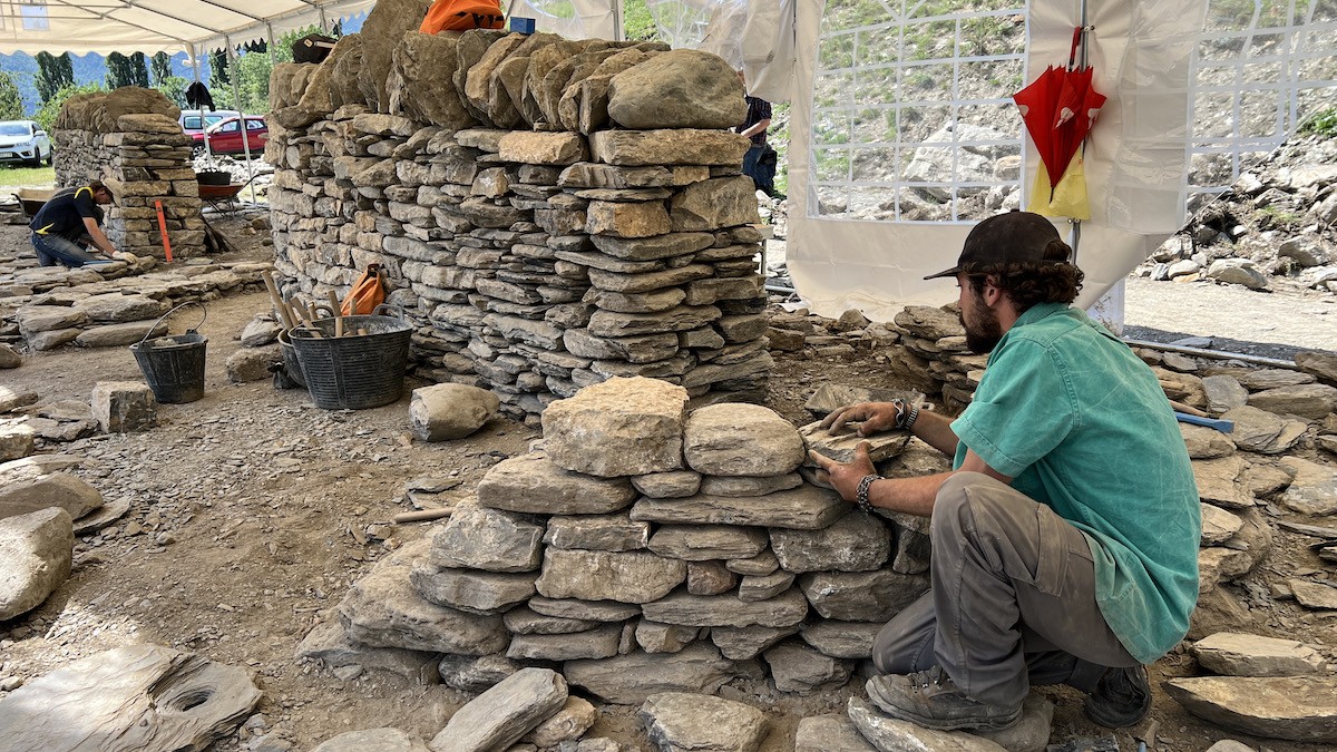 Un alumne del curs de pedra seca construint una paret