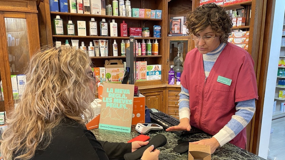 Una dona recollint una compresa de tela en una farmàcia de Tremp
