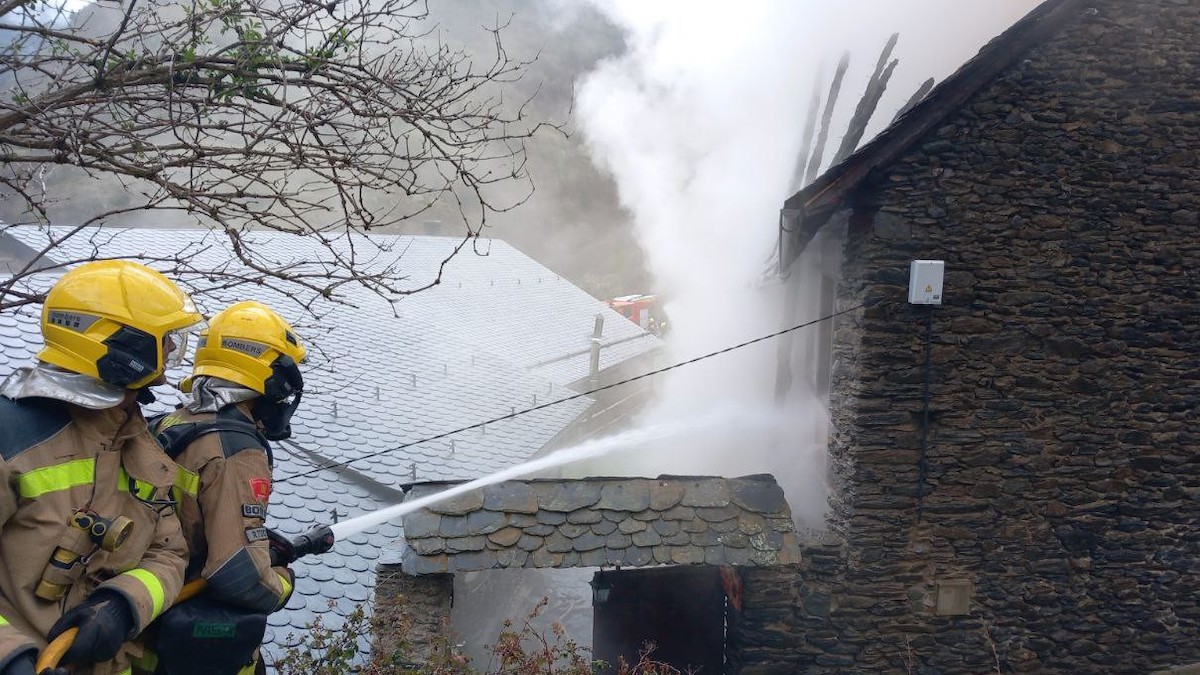Dos bombers apagant l'incendi en una casa d'Estaon