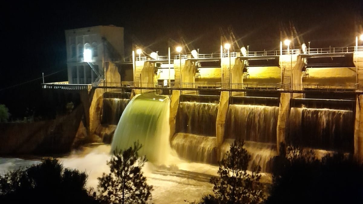 Una de les comportes de la presa oberta en una espectacular vista de nit