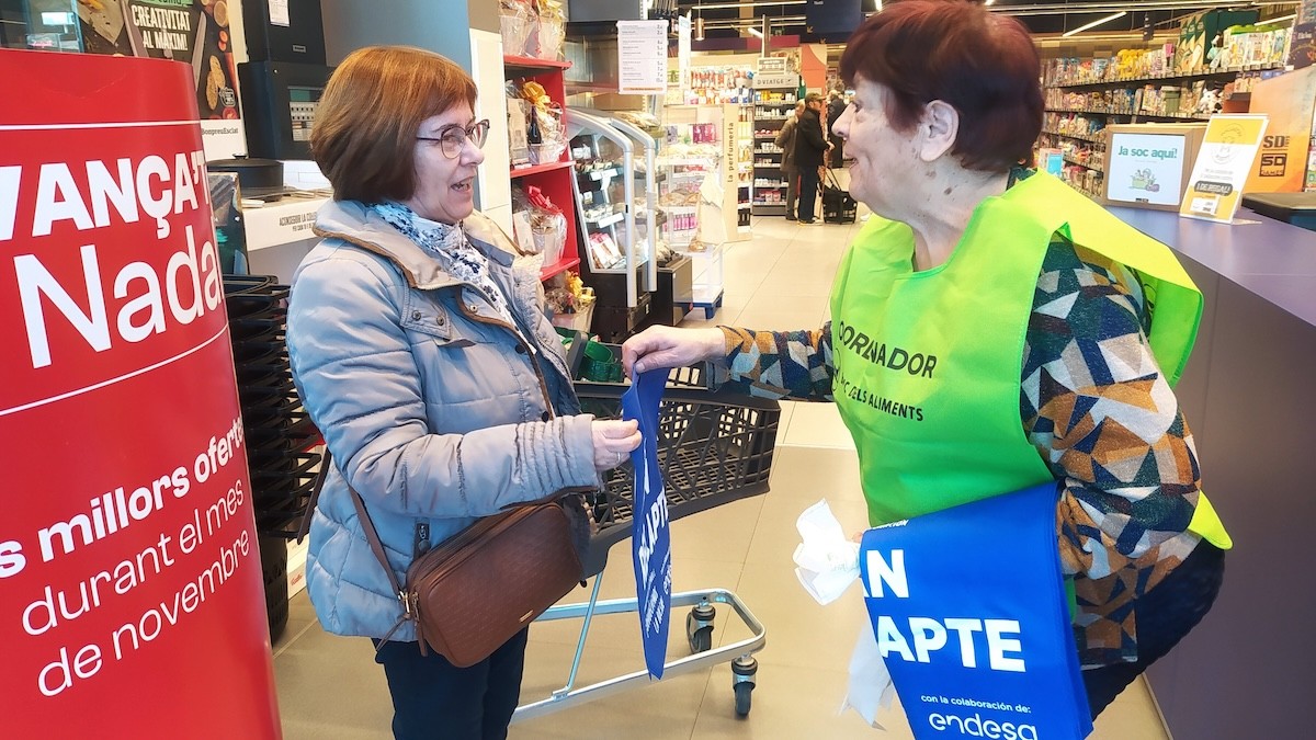 Un voluntària de la campanya amb una clienta en un supermercat de Tremp