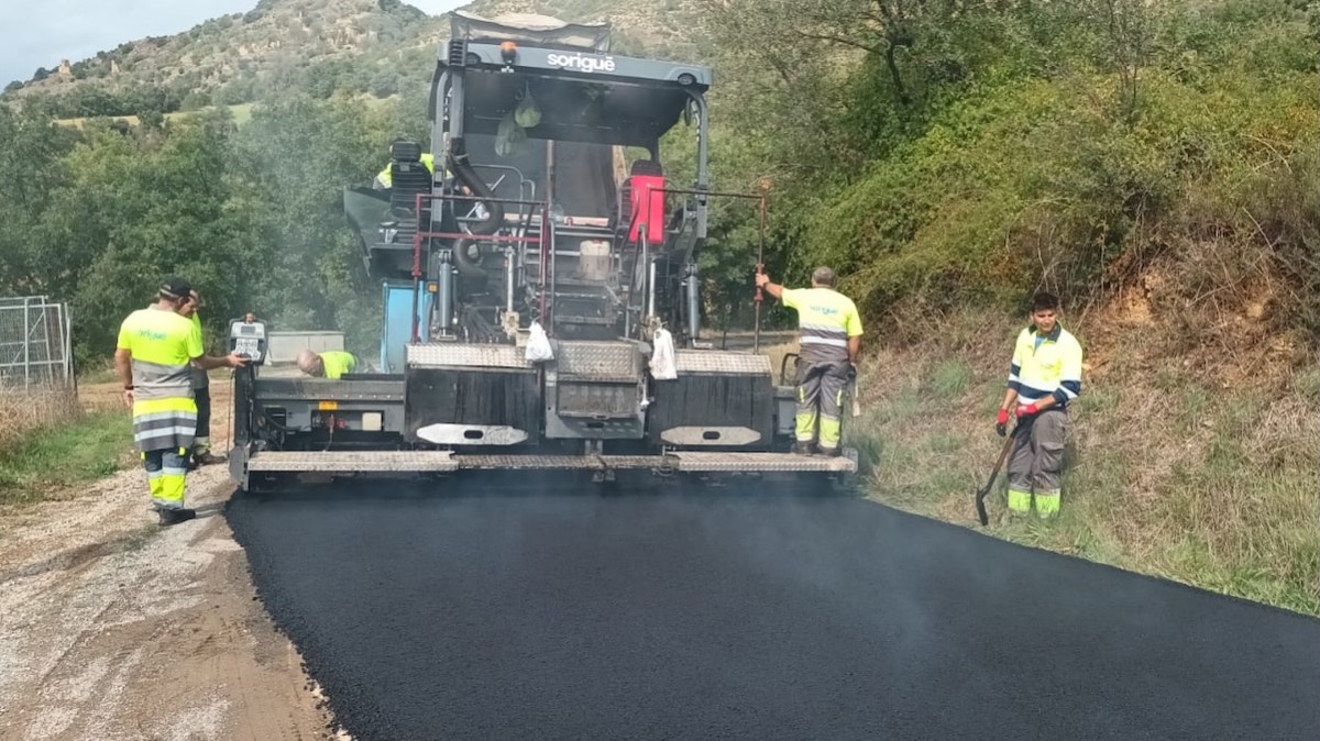Uns operaris asfaltant una carretera pallaresa en una imatge d'arxiu
