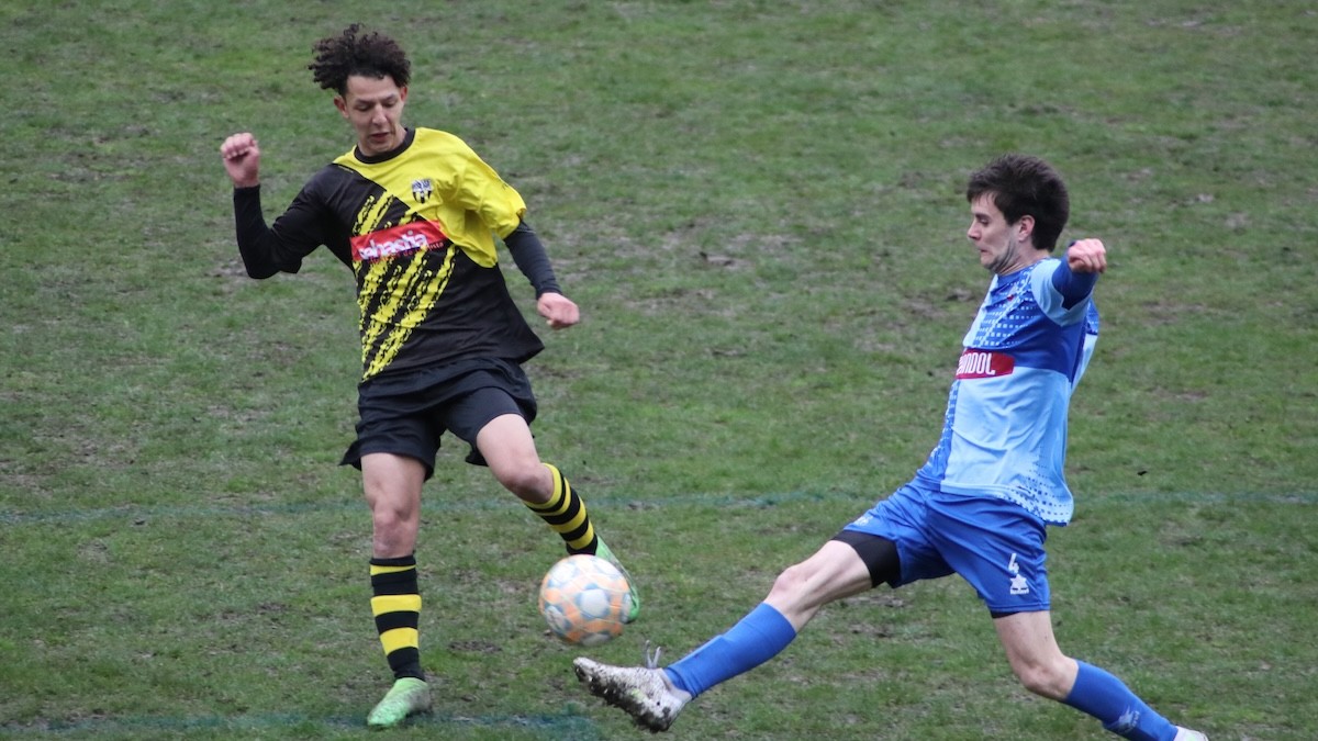 Un jugador del Rialp en una pilota dividida amb un contrari