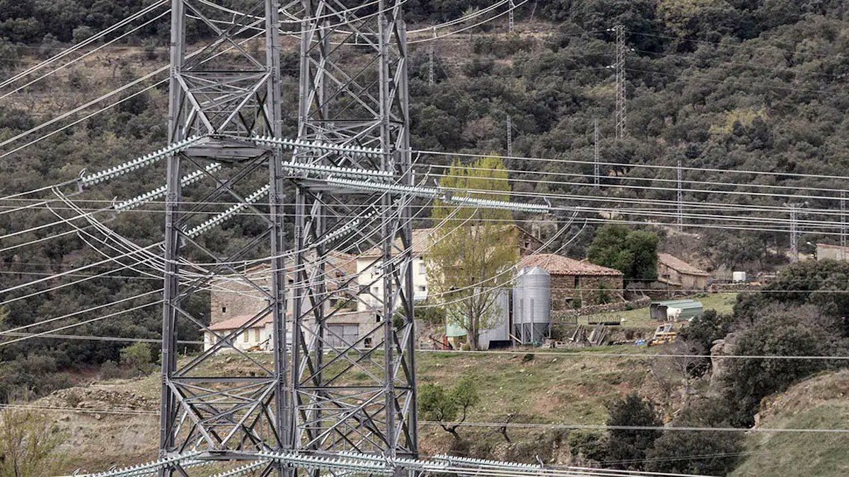Una línia elèctrica prop d’una masia en imatge d’arxiu