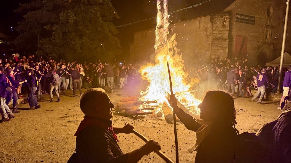 Dos fallaires dansant amb la falla major al fons