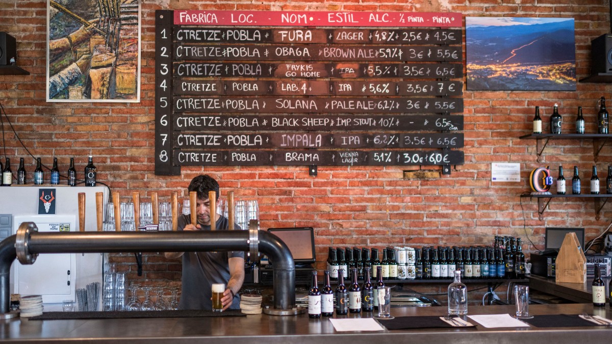 La barra amb els tiradors de cervesa i el llistat de preus de la fàbrica Ctretze