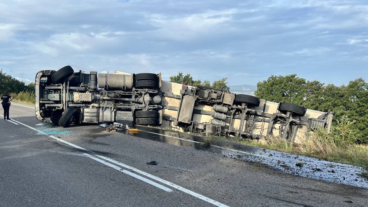 Imatge del camió bolcat al voral de la carretera