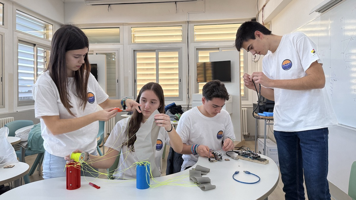 Els quatre estudiants acabant de crear el satèl·lit amb què participaran al concurs