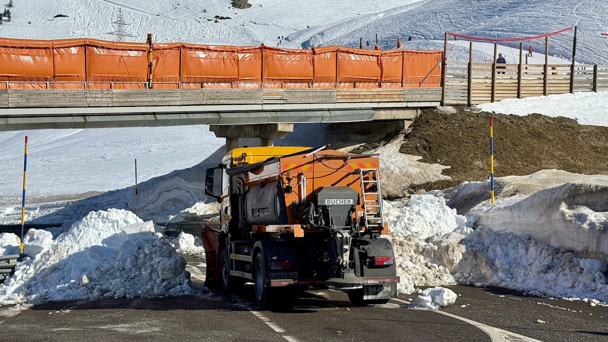 Una muntanya de neu i una màquina llevaneus barren el pas als vehicles