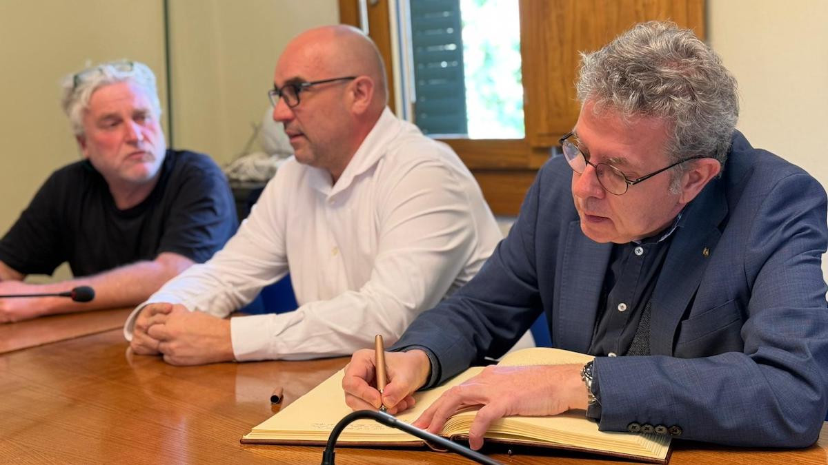 Talarn signant el llibre d'honor de l'Ajuntament de la Pobla de Segur