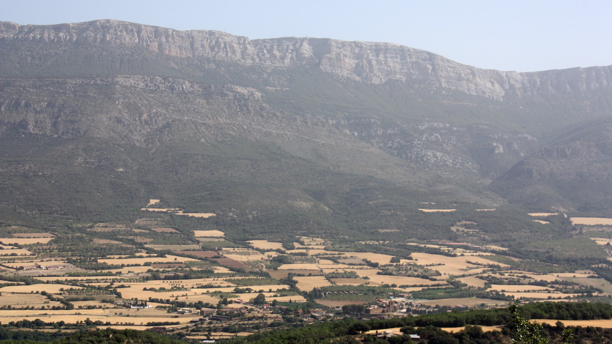 La serra del Montsec i en primer terme, el poble d'Àger, a la Noguera