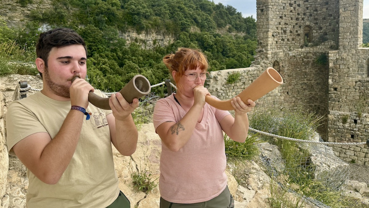 L'arqueòloga Paula Melero i l'estudiant Adrià Belinchón fan sonar dos corns des del Castell de Sant Gervàs