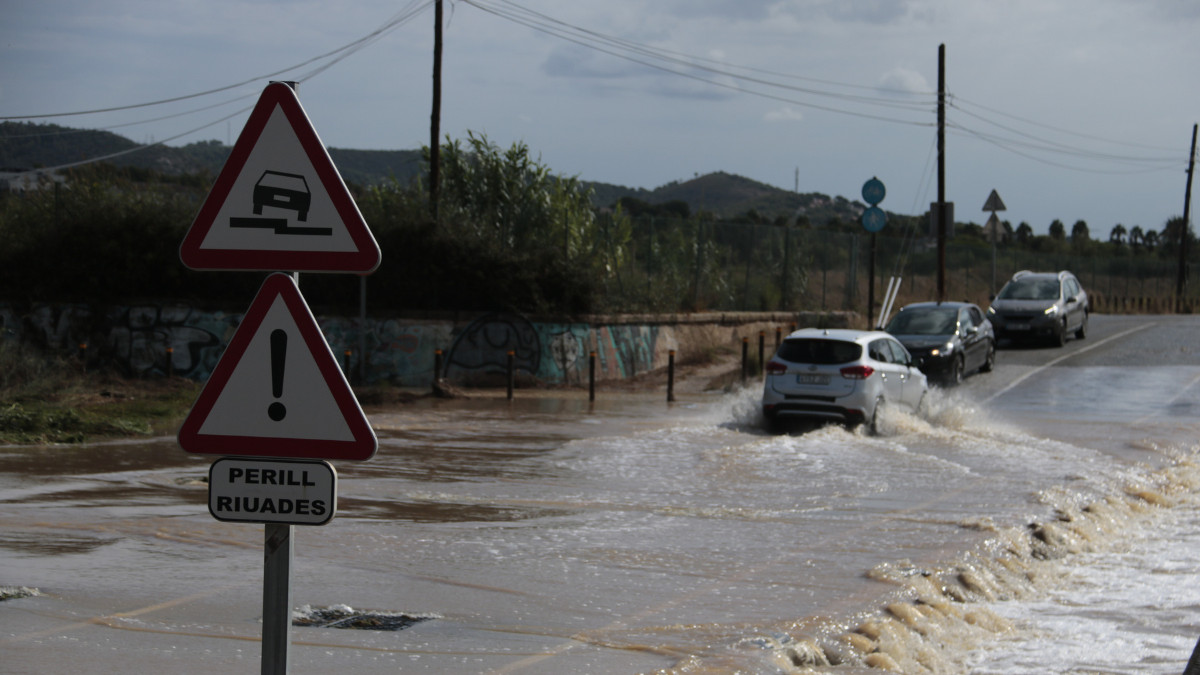 Vehicles circulant per una calçada inundada 